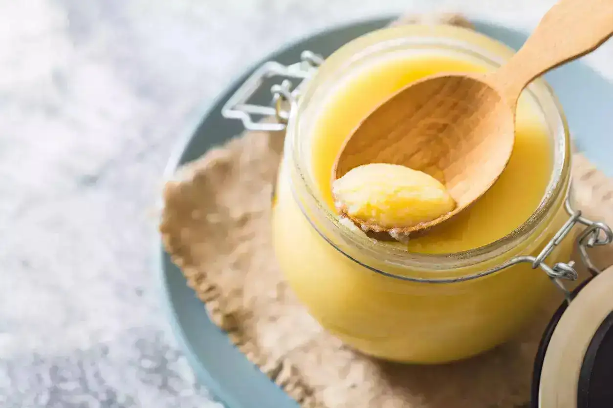 Ghee kept in a spoon over a jar