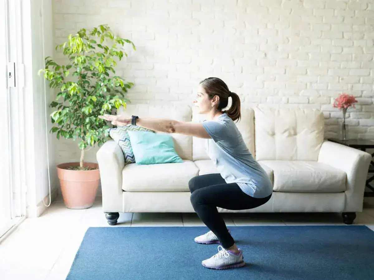 A girl performing squats in a room