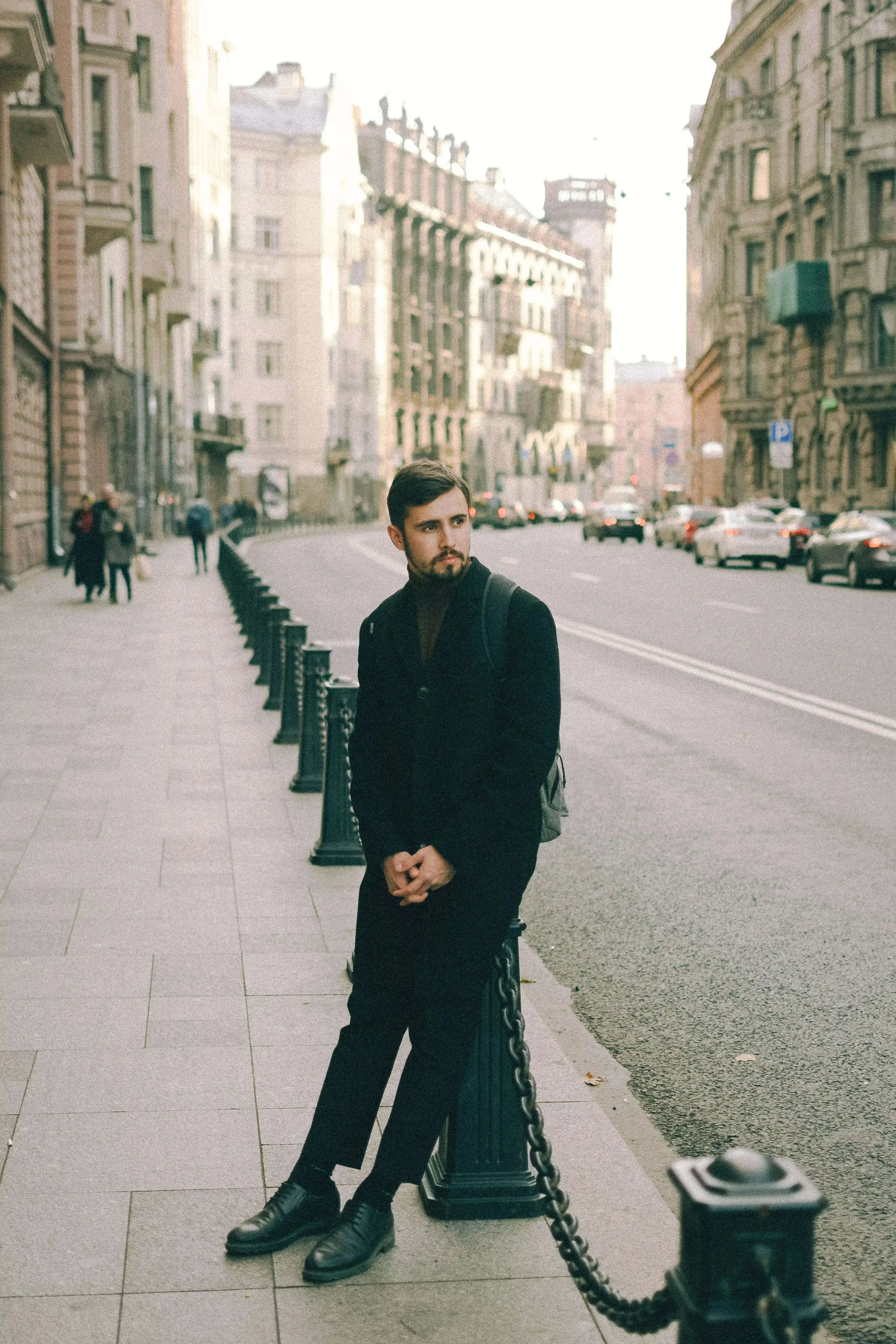 A man standing patiently on the side walk