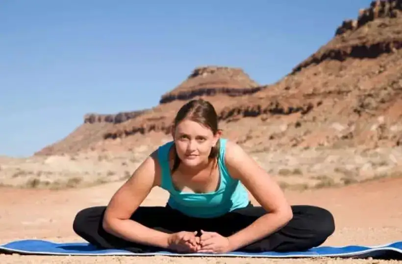 A girl performing butterfly pose outdoors