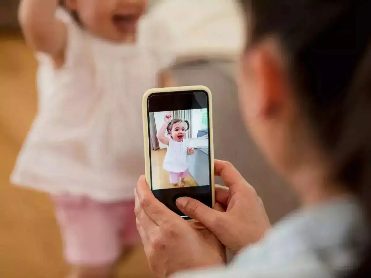 A mom taking the picture of her young daughter