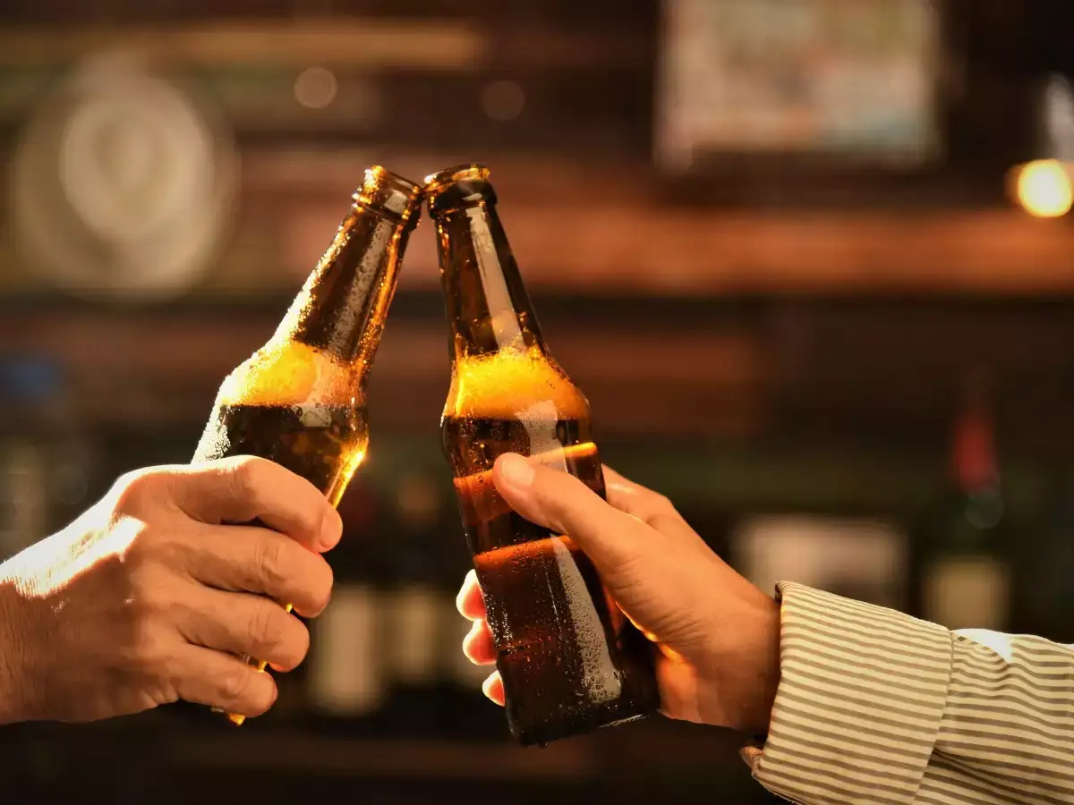 Two people clinking their beer bottles