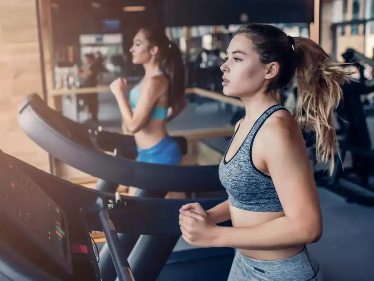 Two girls running on treadmill