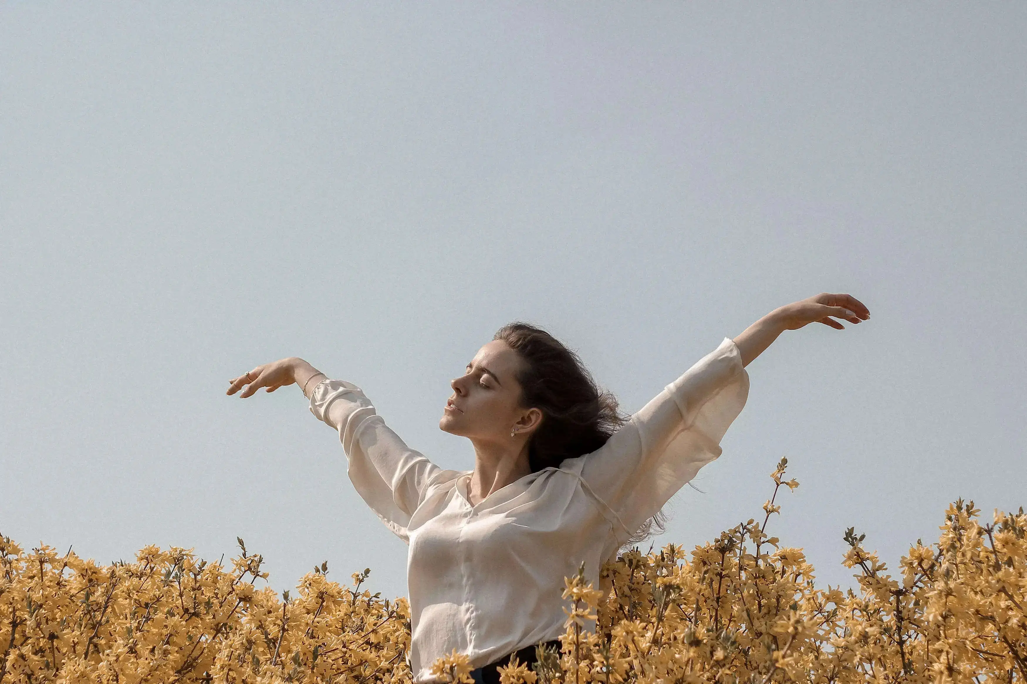 A girl extending her arms amid nature