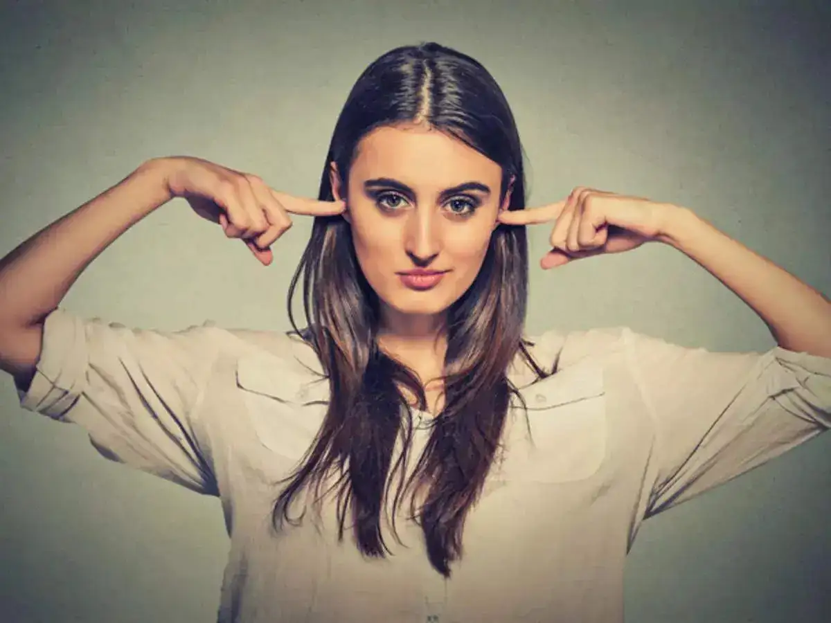 A girl closing her ears using her fingers