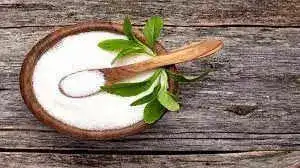 Stevia kept in a wooden bowl with a spoon