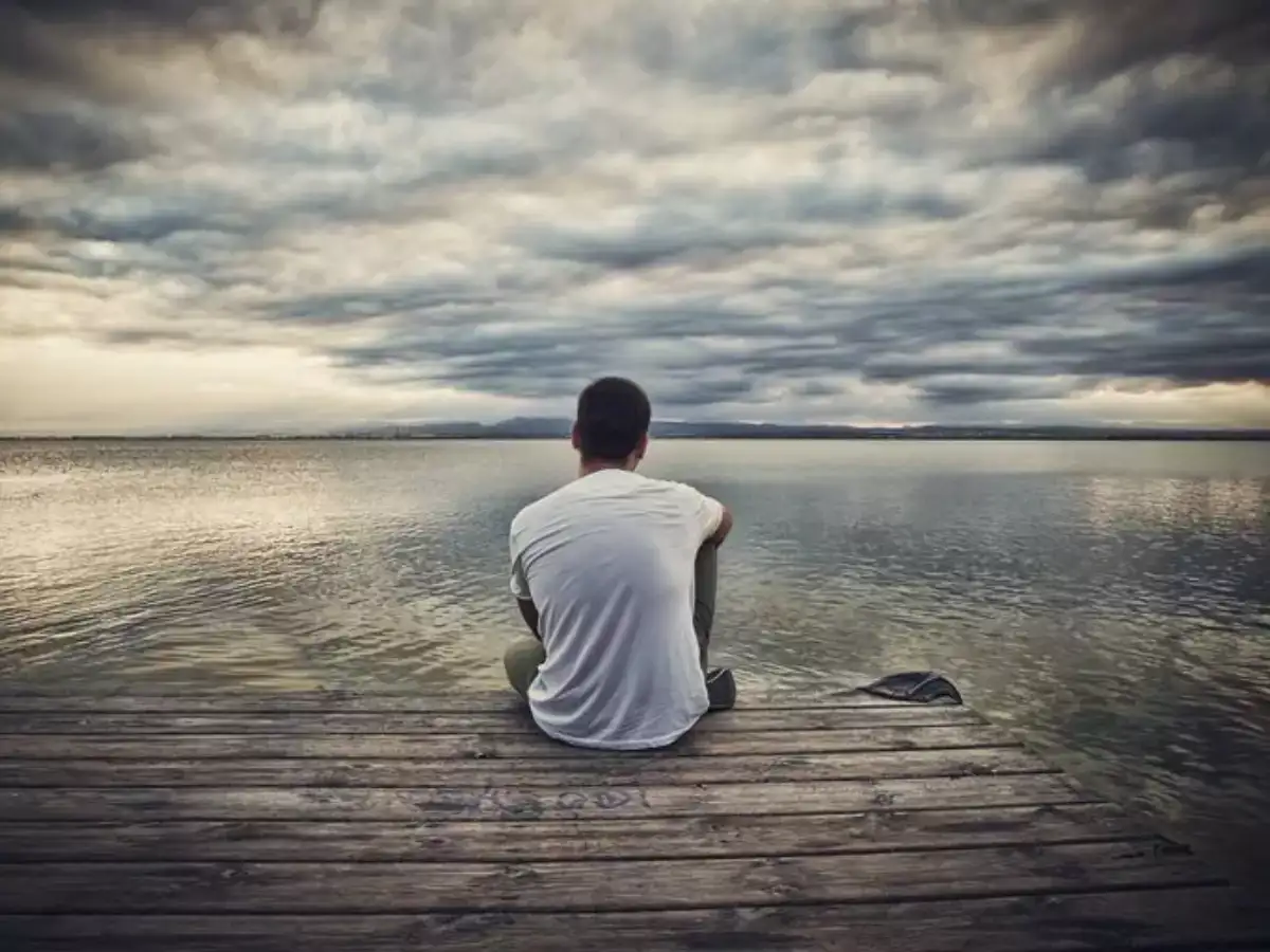 A man sitting by the dock alone