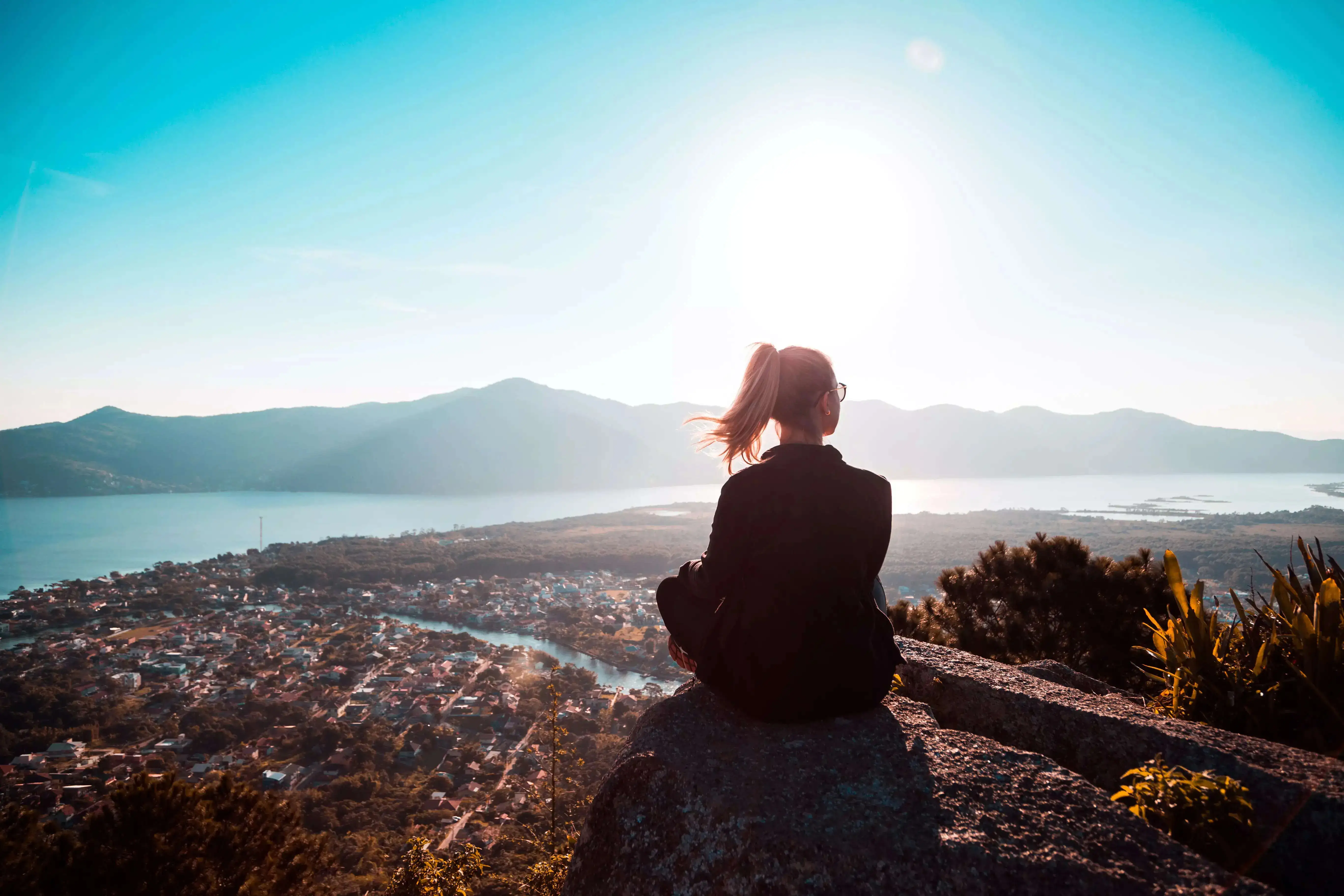 A girl sitting on the edge of a mountain