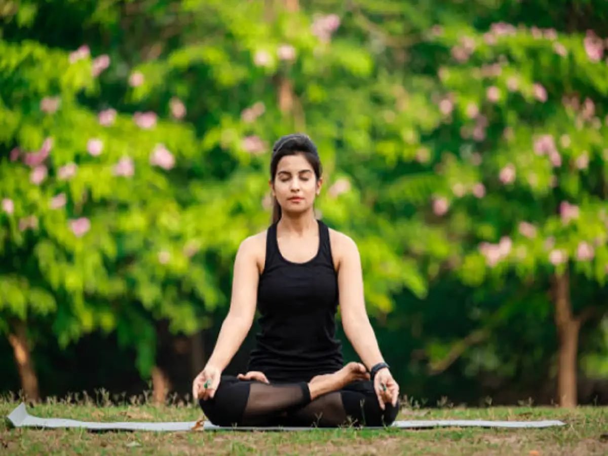 A girl performing meditation in a park