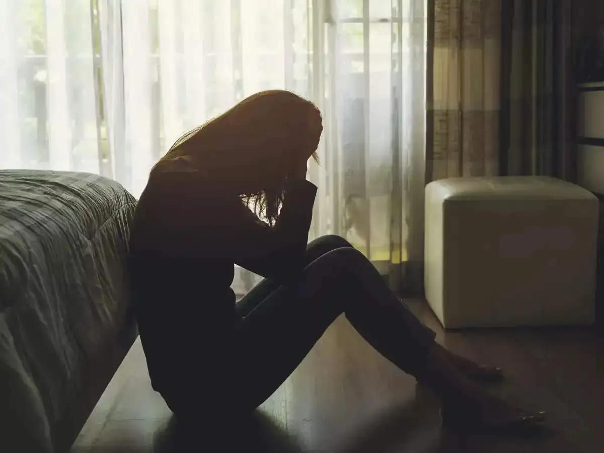 A girl sitting alone in a dimly lit room