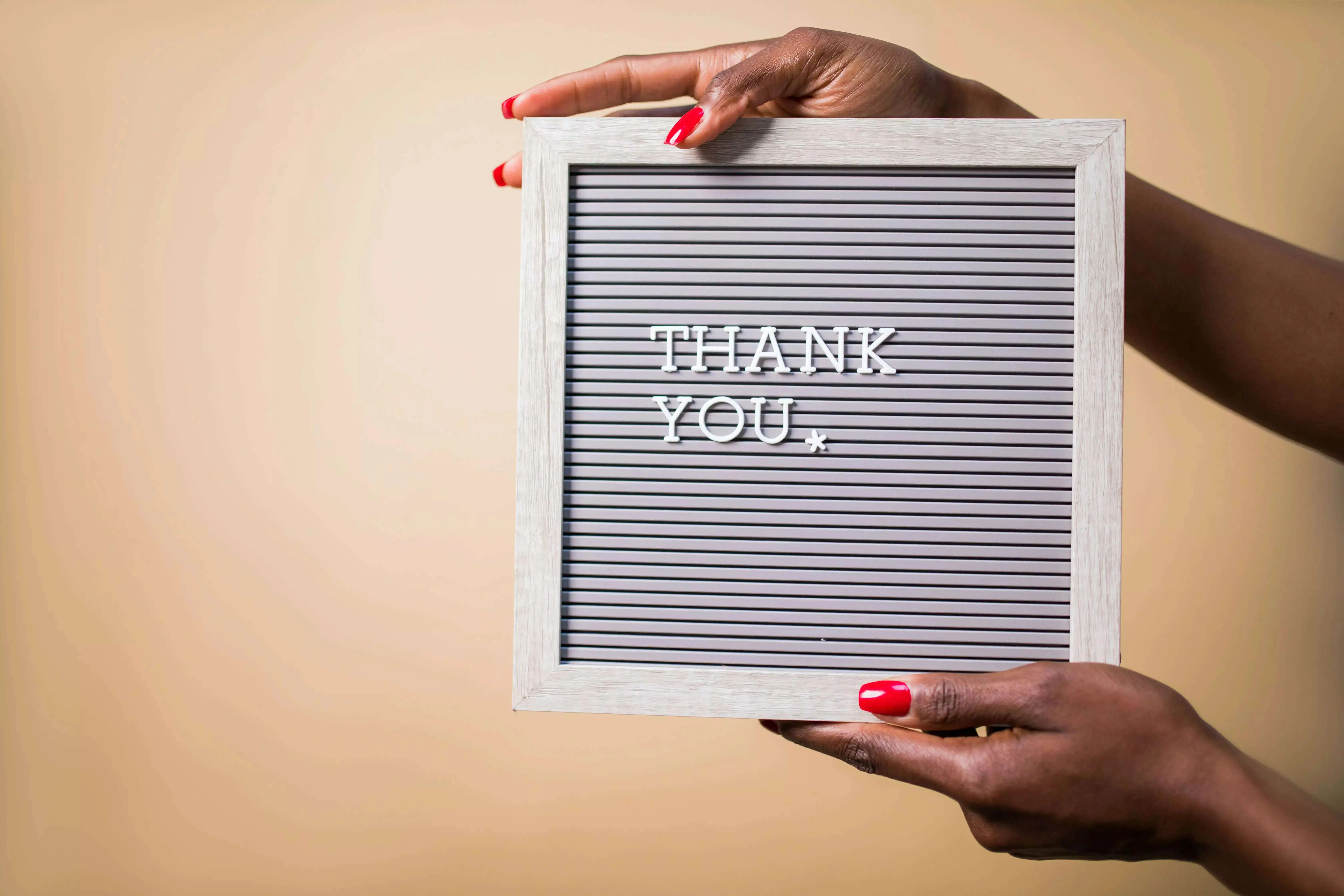 A girl holding a thank you board